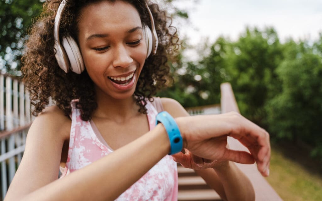 Woman exercises with headphones and smartwatch.
