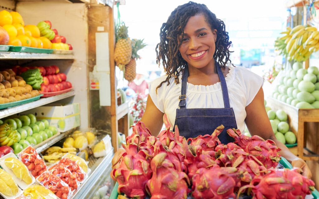 Woman at supermarket holding dragonfruit