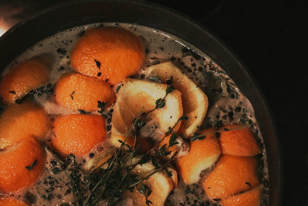 a pot filled with oranges and herbs