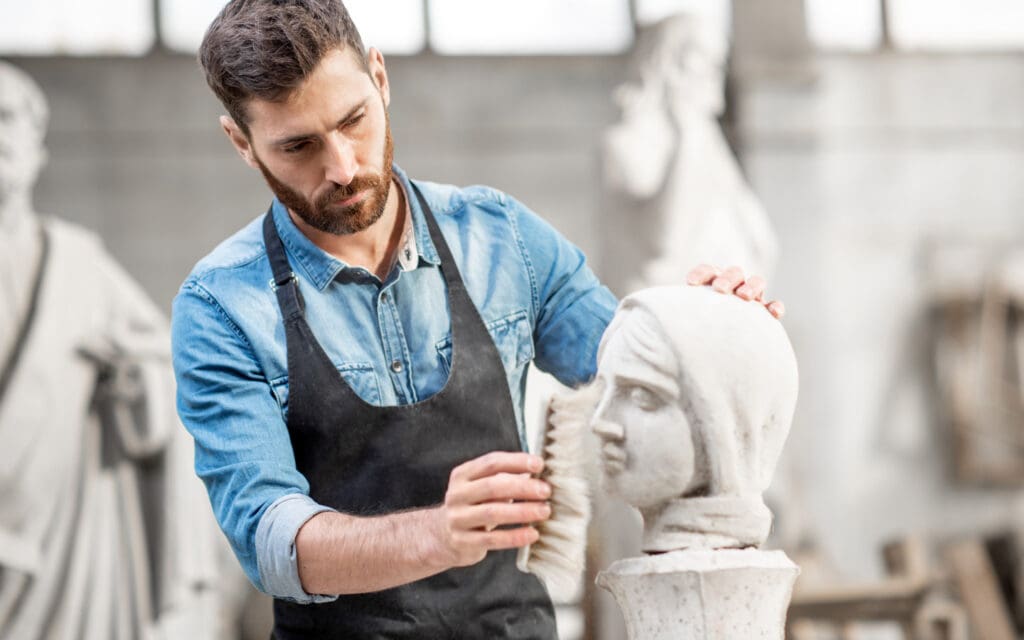 man sculpting in art studio