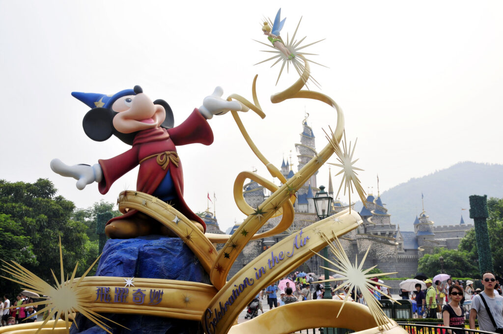 Tourists walk past a statue of Mickey Mouse at the Hong Kong Disneyland Resort in Hong Kong, China, 10 July 2011