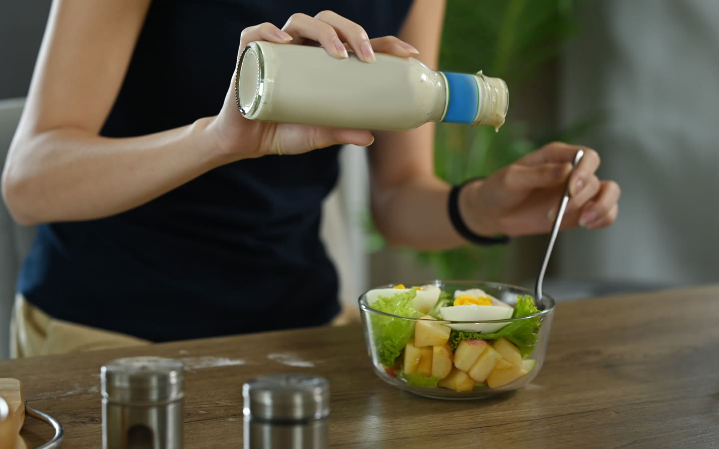 woman putting ranch on salad