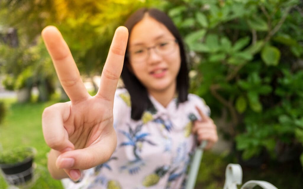 young asian girl making peace sign