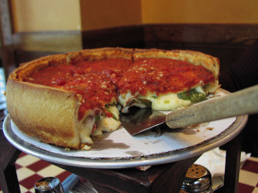A Chicago-style pizza on a silver platter