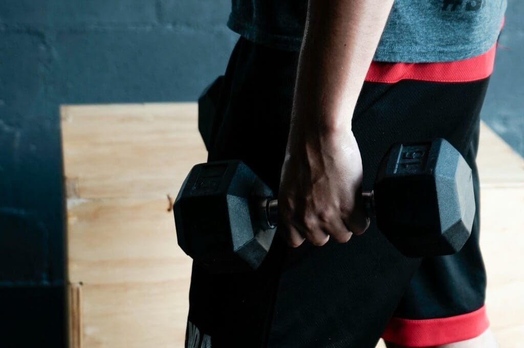 unknown person holding black dumbbell