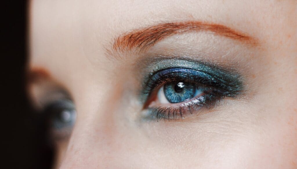 a close up of a woman's eye with blue eyeshadow