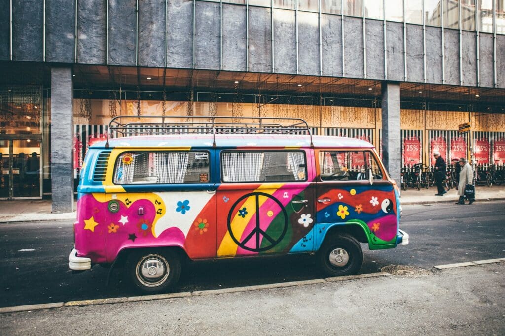 multicolored minivan parked on roadside near building