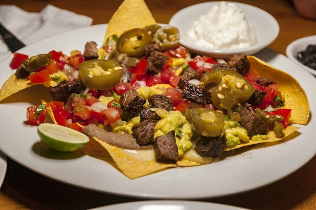 a white plate topped with nachos covered in toppings