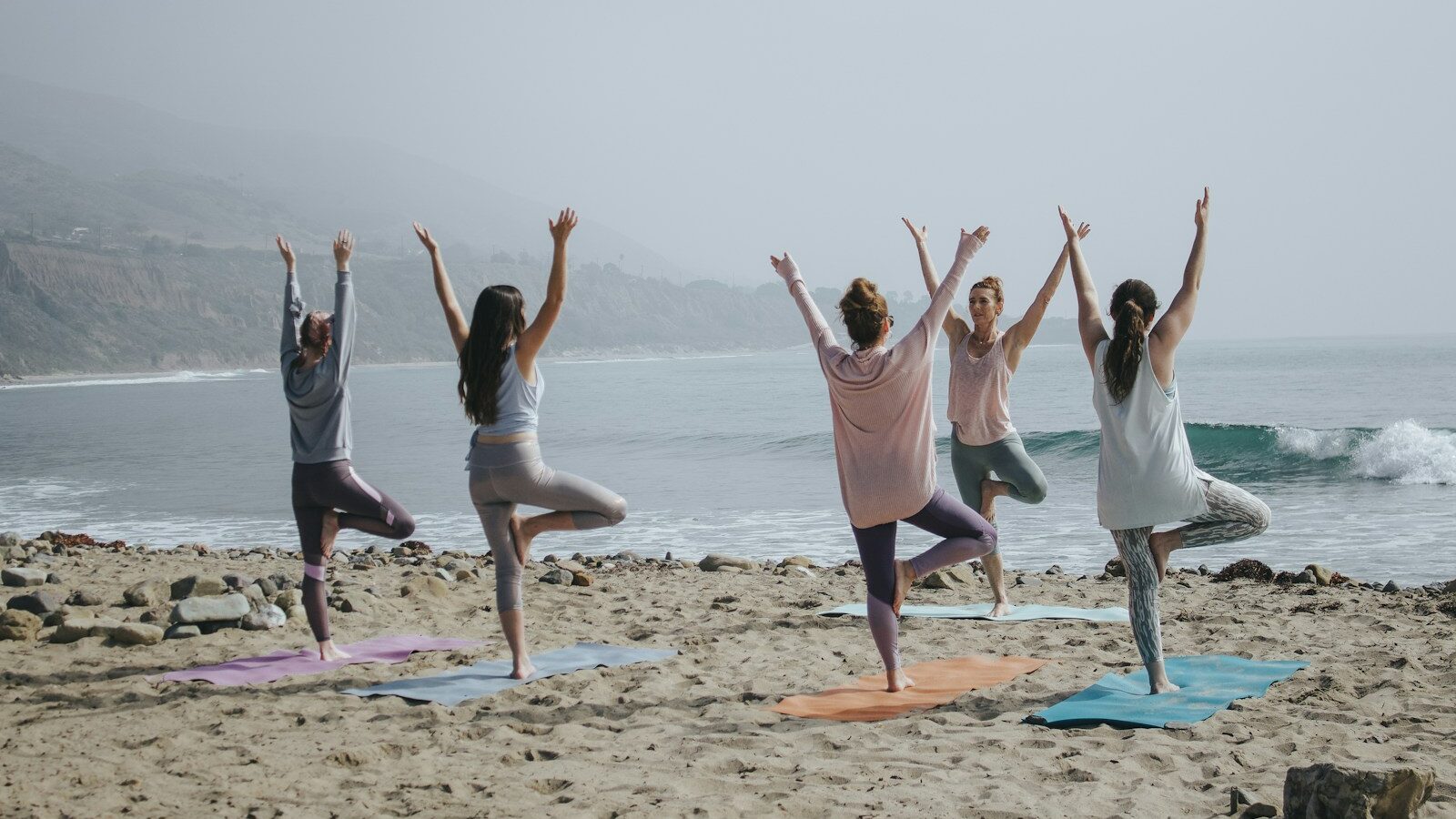 five woman standing on seashore