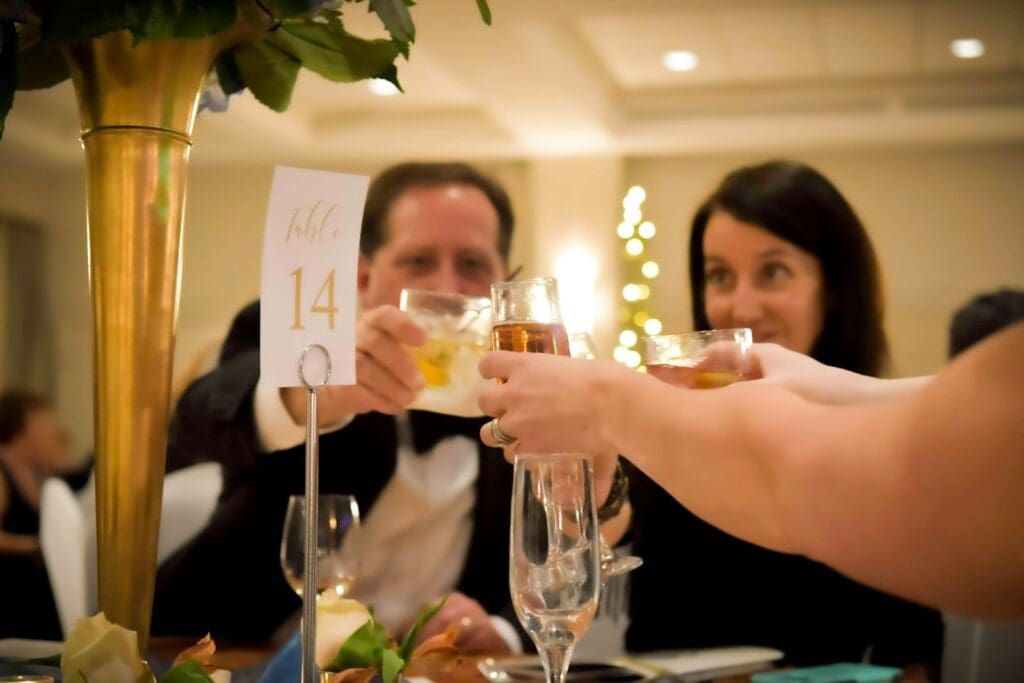 people holding white card and drinking glasses