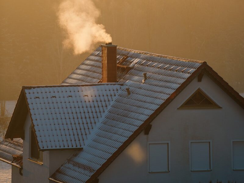 smoke coming out of a chimney on top of a house