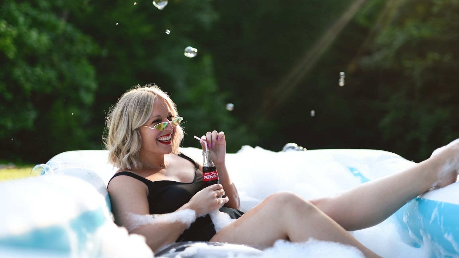 woman in black tank top and black shorts sitting on white textile