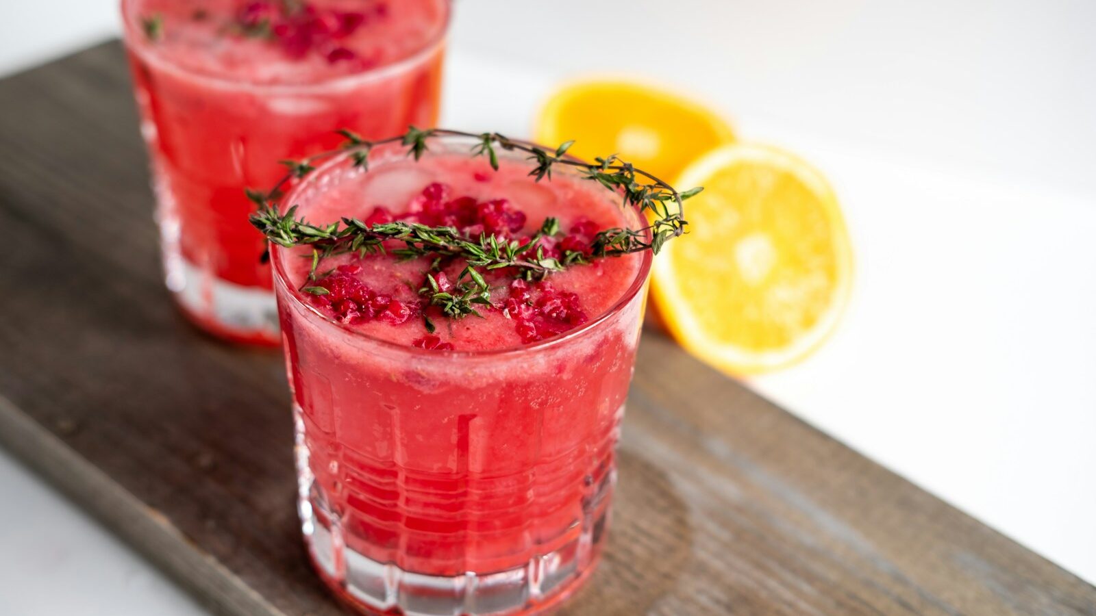 clear drinking glass with red liquid and sliced lemon