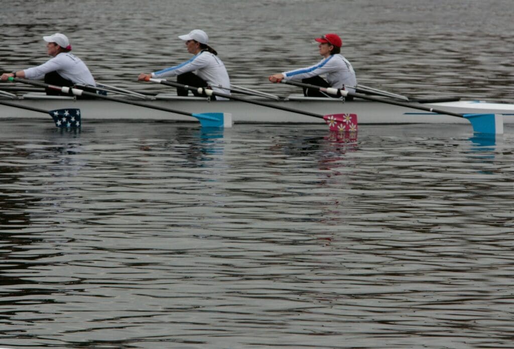 a row of rowers rowing on the water