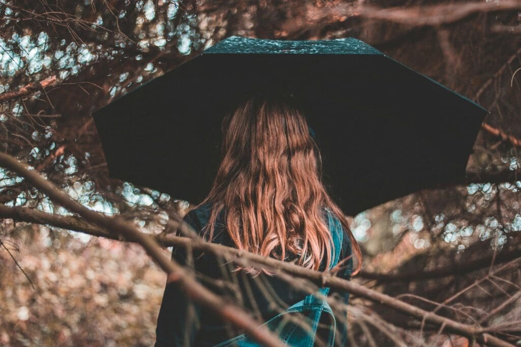 woman standing while holding black umbrella