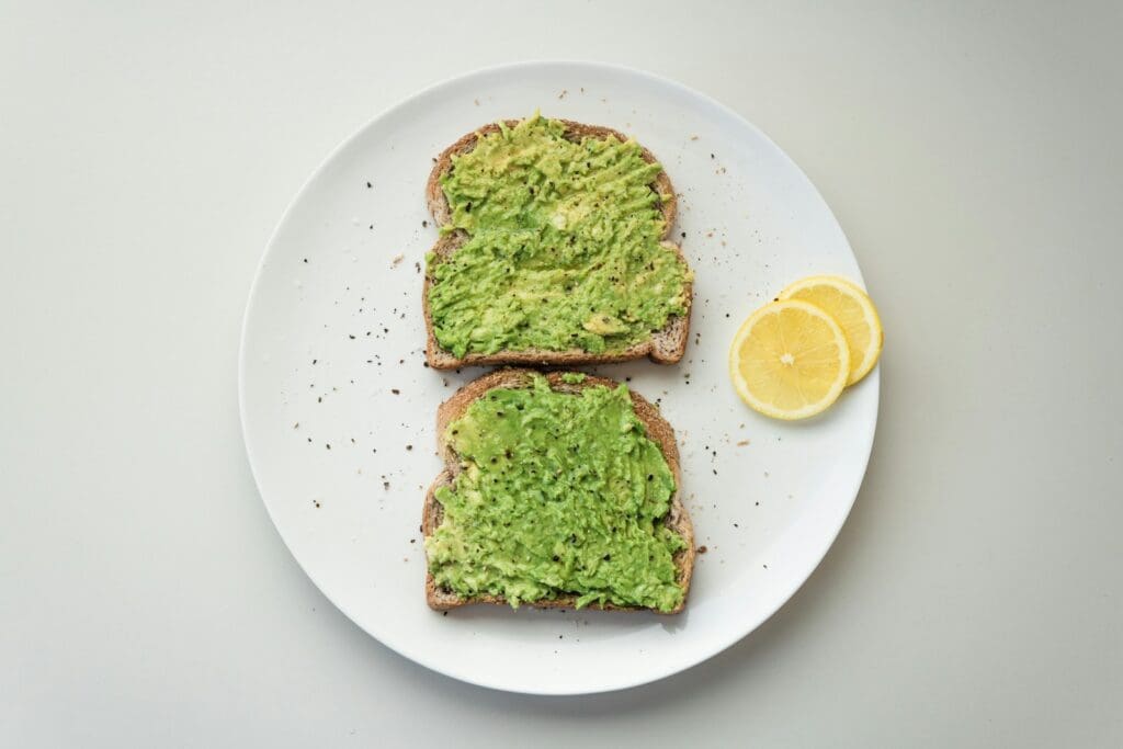 green and brown avocado on white ceramic plate