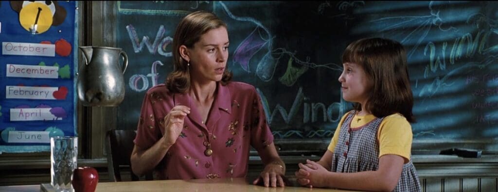 A little girl talking to her teacher as a jug of water floats