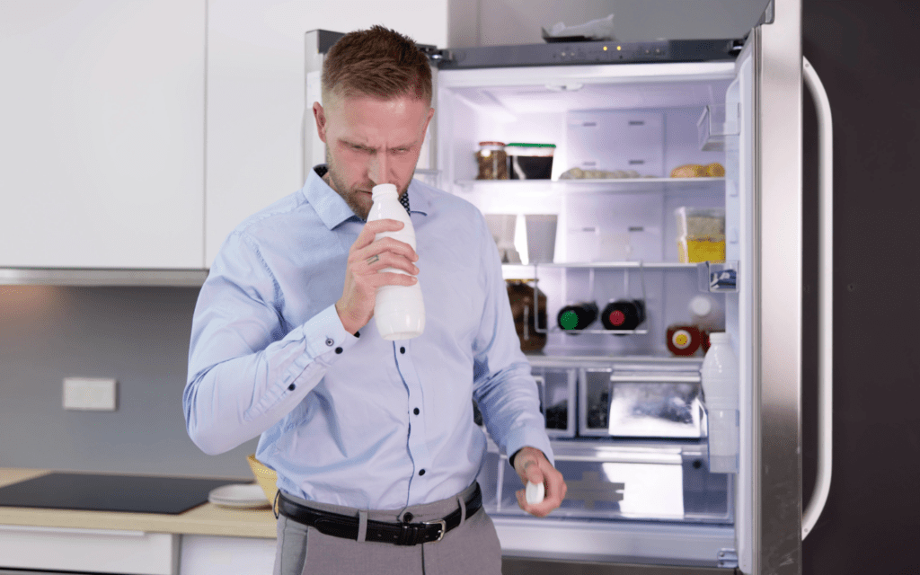 Adobe Stock, smelling milk to check freshness