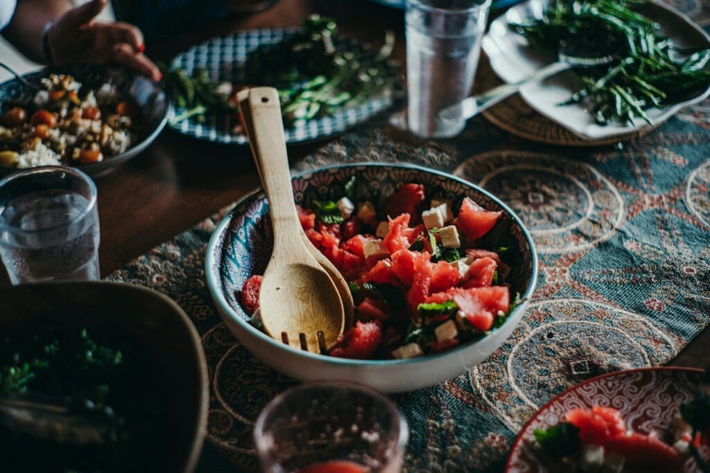 a bowl of watermelon salad with a wooden spoon