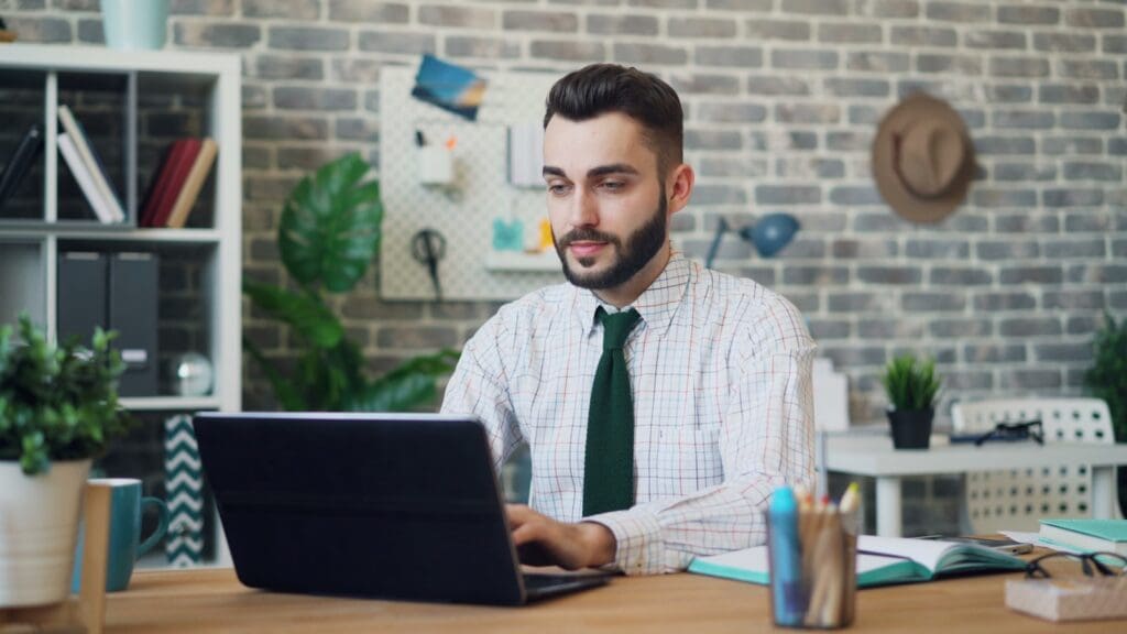 a man sitting in front of a laptop computer