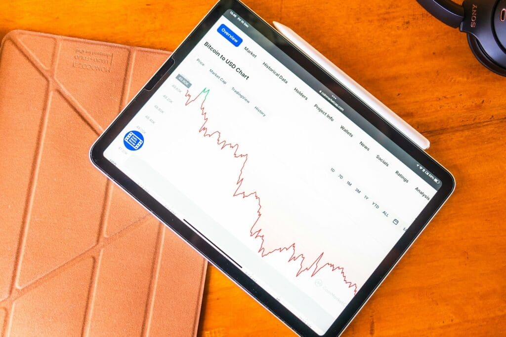 a tablet computer sitting on top of a wooden table investing concept