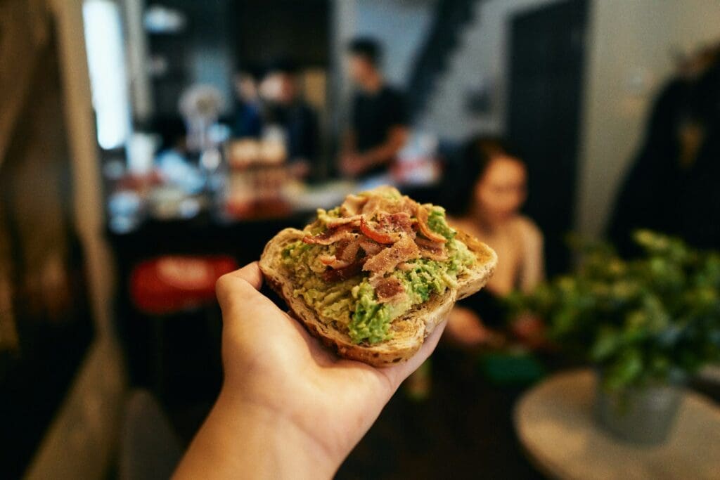 person holding green and brown food