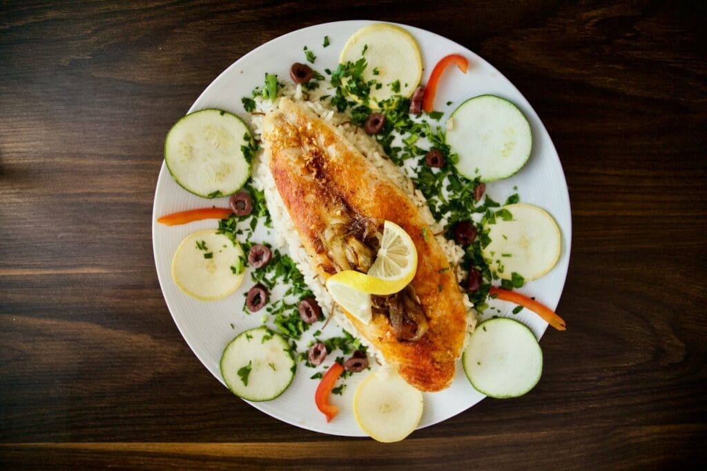 a white plate topped with fish and vegetables