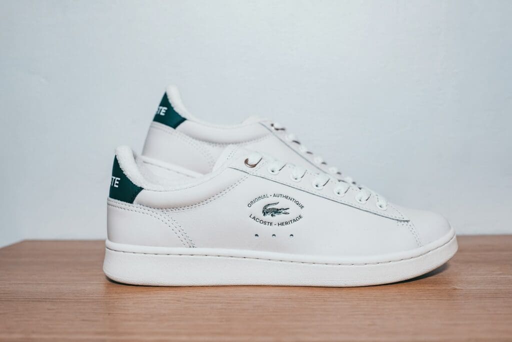 A white and green sneaker on a wooden table