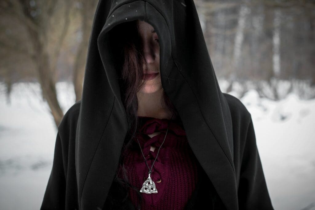 person in black hoodie standing on snow covered ground during daytime