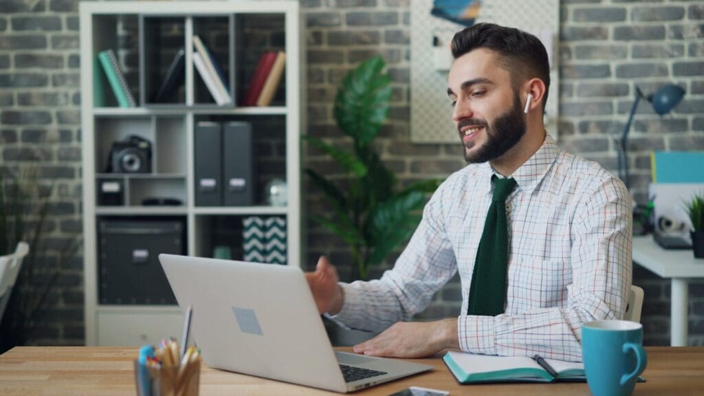 a man sitting at a desk using a laptop computer