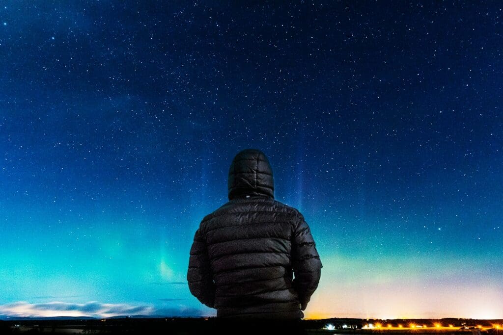 man in black bubble hoodie looking at the stars