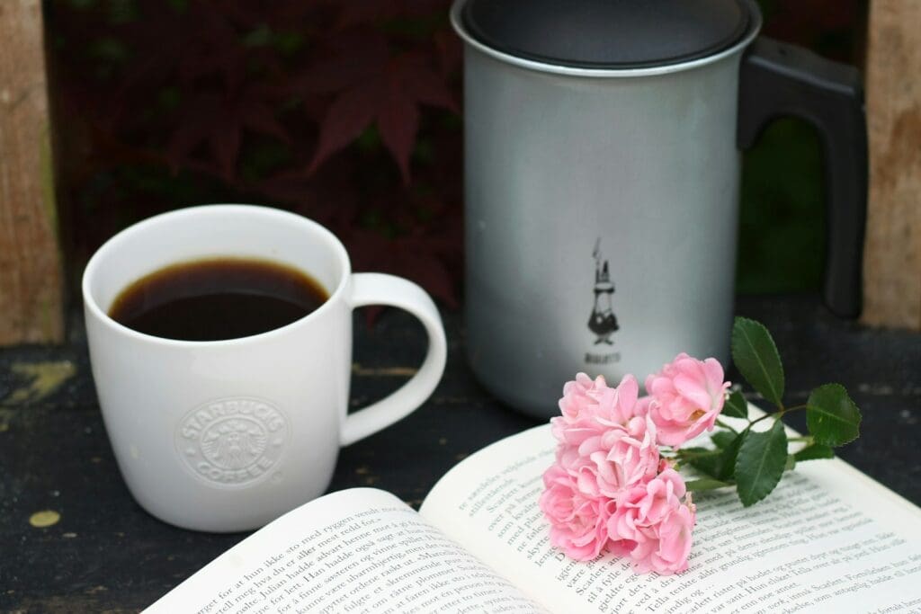 a cup of coffee and a book on a table