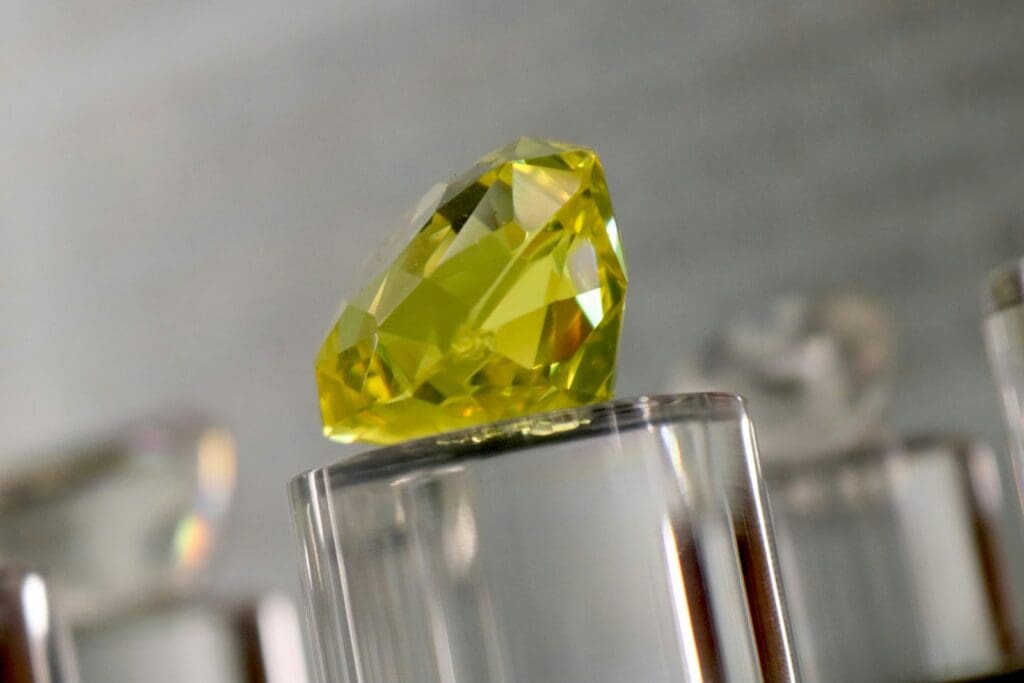 a yellow diamond sitting on top of a glass block