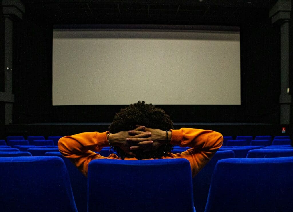 a person sitting in a chair in front of a projection screen