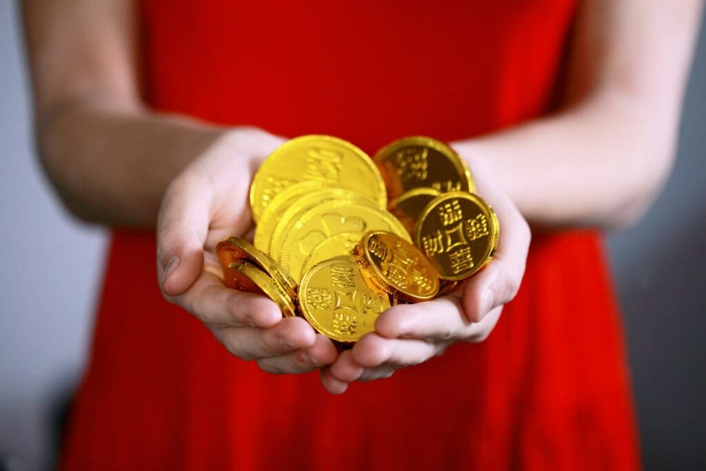 person holding gold-colored ching coins