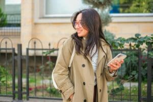 Smiling Woman in Eyeglasses and Trench Coat