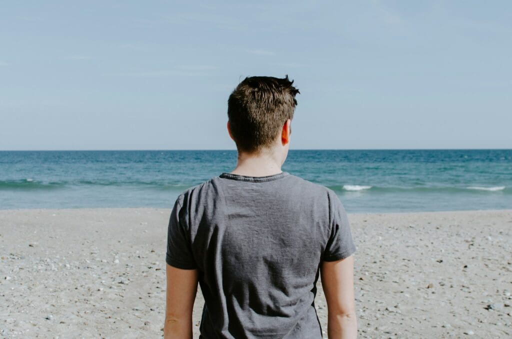 man standing on beach shore during daytime