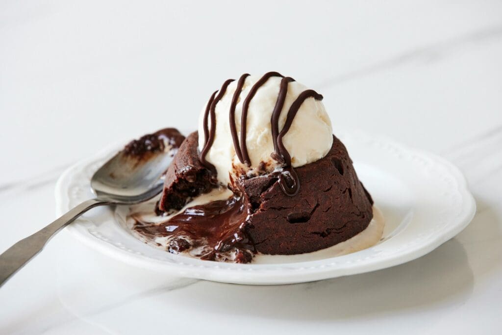 a white plate topped with a piece of cake and ice cream