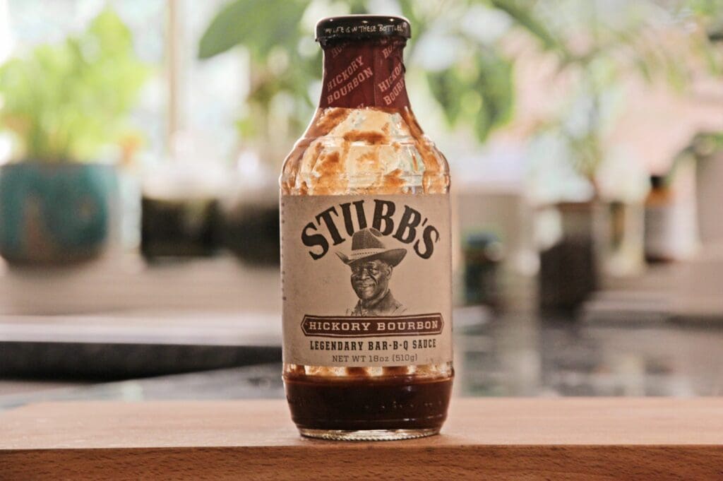 a bottle of hot sauce sitting on top of a wooden table