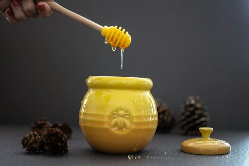 opened yellow ceramic jar beside pine cones