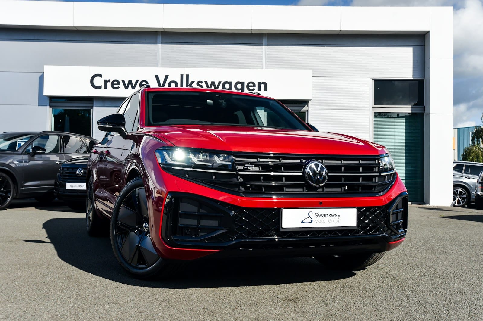 a red volkswagen suv parked in front of a building