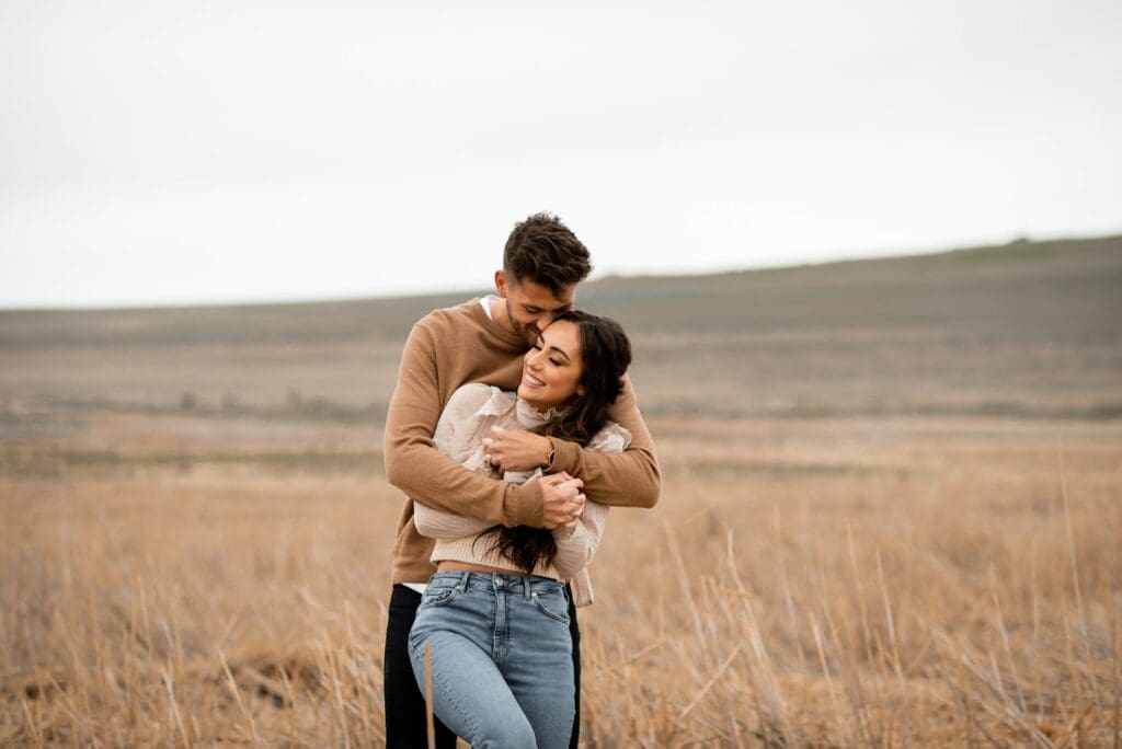 A man and a woman hugging in a field