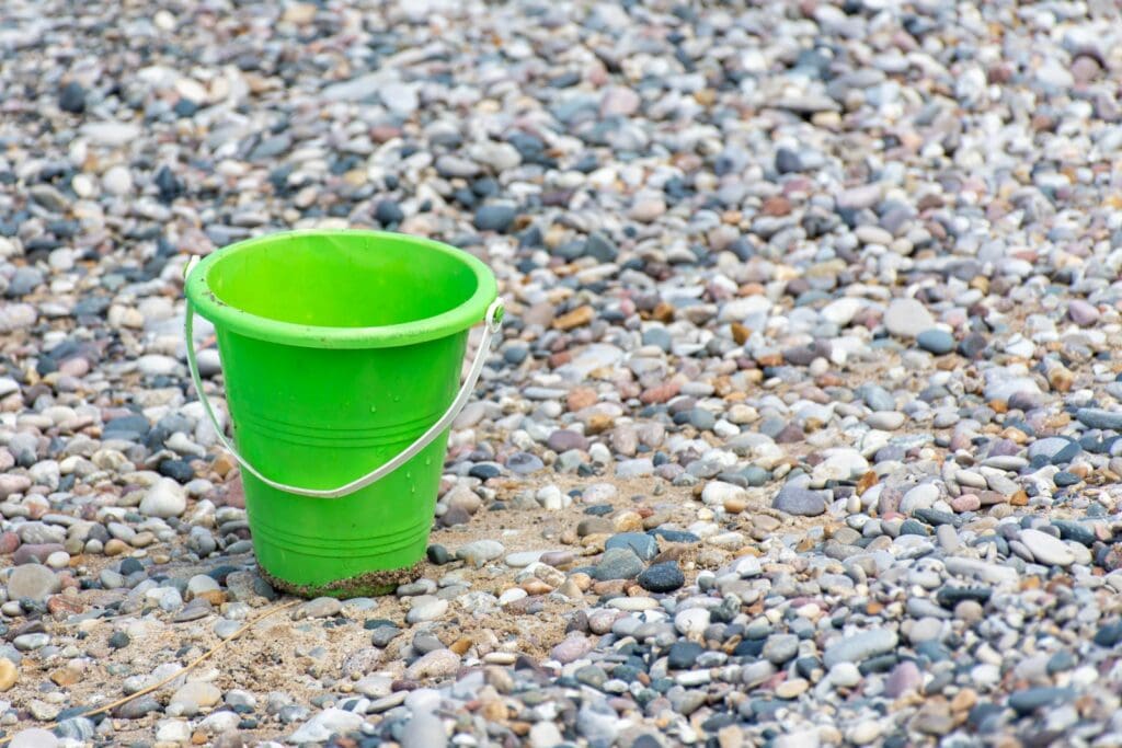 Green plastic bucket on stones