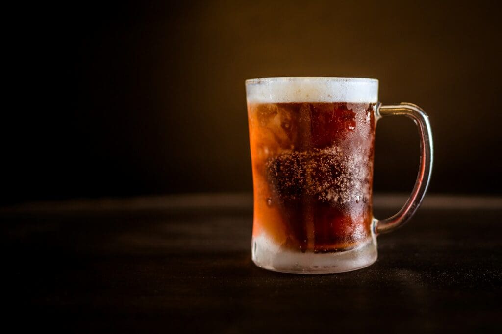 brown liquid on clear glass mug