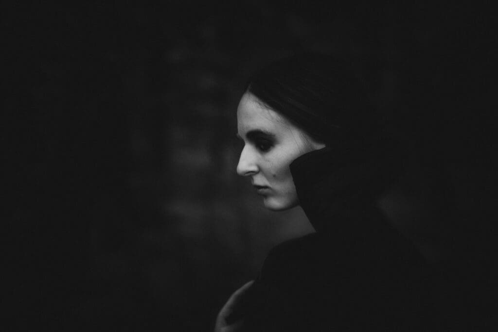 A black and white photo of a woman in the dark