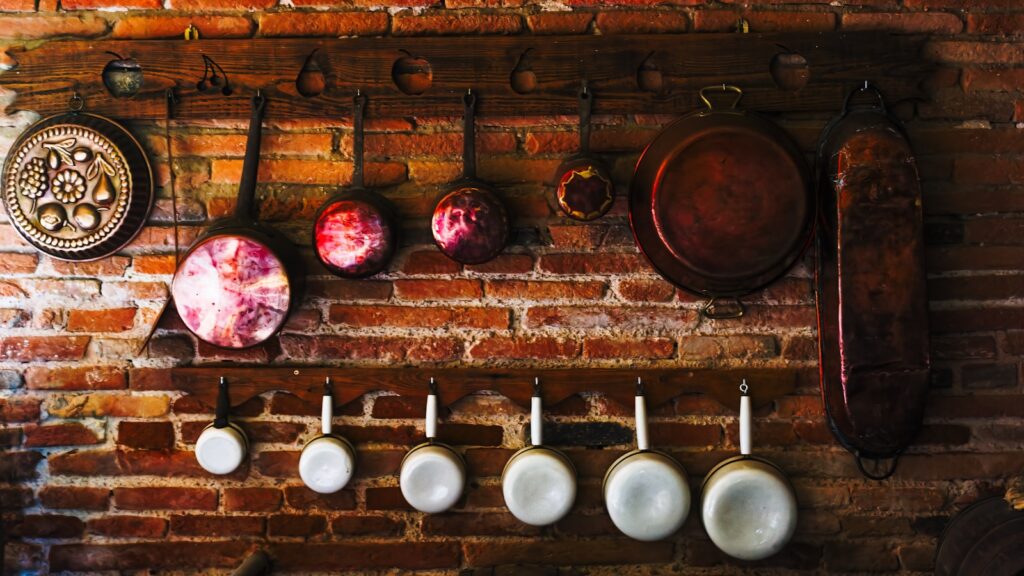 a brick wall with pots and pans hanging on it