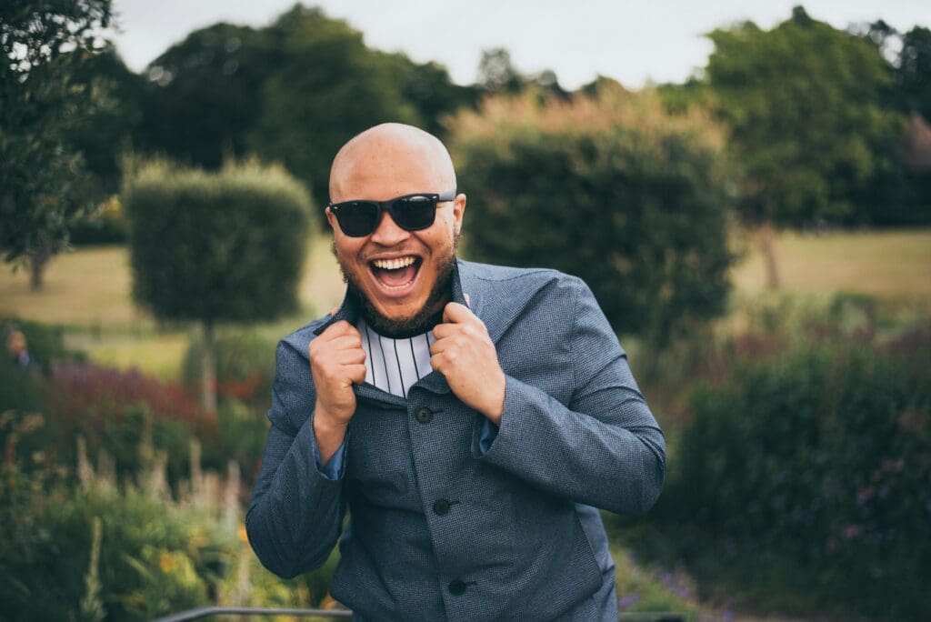 man in gray suit jacket wearing black sunglasses