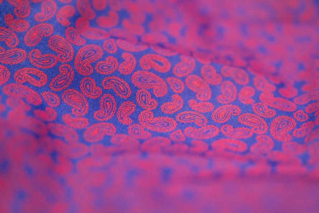 a close up of a pink and blue tie