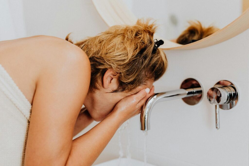 Woman Washing Face in Bathroom