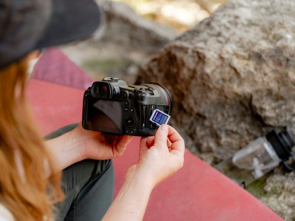 A woman taking a picture of a rock with a camera